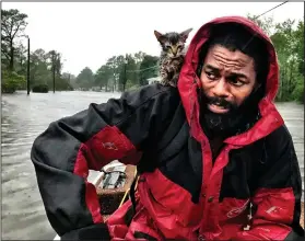  ?? Andrew Carter/The News & Observer via AP ?? Survivors: Robert Simmons Jr. and his kitten "Survivor" are rescued from floodwater­s after Hurricane Florence dumped several inches of rain in the area overnight, Friday in New Bern, North Carolina.