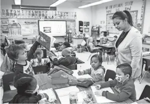  ?? JULIA NIKHINSON/AP ?? Christine Ramroop, who graduated from Bowie State University in 2020, teaches first graders at Whitehall Elementary School in Bowie, Md.