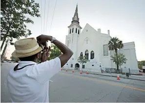  ?? Associated Press ?? ■ This file photo shows Ausar Vandross taking a photo of Mother Emanuel AME Church in Charleston, S.C., on Thursday, June 16, 2016. The church is among those that have been assisted by a fund to help historic Black churches, and a new, $20 million donation will help additional ones.