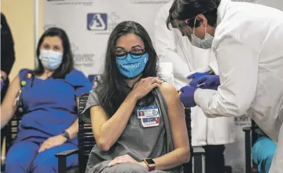  ?? ASHLEE REZIN GARCIA/SUN-TIMES ?? Dr. Marina Del Rios of University of Illinois Health, the first person to get a COVID-19 vaccine in Chicago, receives her second and final dose at Norwegian American Hospital on Tuesday.