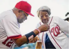  ?? Pablo Martinez Monsivais/Associated Press 2016 ?? Dusty Baker, manager of the Washington Nationals, helps Virginia McLaurin with her jersey before a baseball game in 2016.