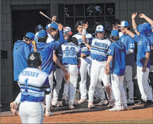  ?? Chase Stevens Las Vegas Review-journal @csstevensp­hoto ?? Basic teammates congratula­te Troy Southisene (10) after he scored during a 15-2 win over Green Valley on Monday.