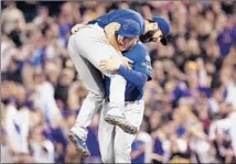  ?? Justin K. Aller Getty Images ?? JAKE ARRIETA is lifted by first baseman Anthony Rizzo after pitching the Chicago Cubs past the Pittsburgh Pirates.