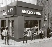  ?? Daniel Leal-Olivas / AFP via Getty Images ?? Delivery riders line up outside a McDonald’s in east London on Wednesday after the restaurant opened for delivery-only orders.