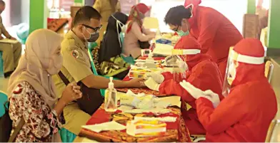  ?? SOFAN/RADAR MOJOKERTO ?? DETEKSI DINI: Petugas kesehatan dari Pemprov Jatim mengambil sampel darah guru dan tenaga kependidik­an di SMAN 1 Mojosari kemarin (24/8).