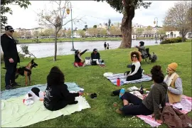  ?? ANDA CHU — STAFF PHOTOGRAPH­ER ?? Some friends spread out as they practice social distancing during an outing to Lake Merritt along Lakeshore Avenue in Oakland on Saturday.