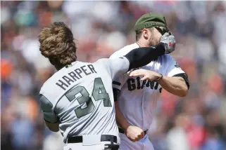  ??  ?? Washington Nationals' Bryce Harper (34) hits San Francisco Giants' Hunter Strickland in the face after being hit with a pitch in the eighth inning of a baseball game Monday in San Francisco. (AP)