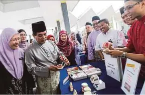  ?? HAFIZ SOHAIMI
PIC BY ?? Datuk Seri Dr Hilmi Yahaya, accompanie­d by Oral Health principal director Datuk Dr Noor Aliyah Ismail (left), visiting an exhibition booth at the National Mosque in Kuala Lumpur yesterday.