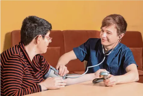  ?? Foto: Georg Drexel / Dominikus Ringeisen Werk ?? Das Blutdruckm­essen gehört für Johannes Saumweber (rechts) zum Alltag in seiner Ausbildung zum Altenpfleg­er. In den Wohneinric­htungen des Dominikus Ringeisen Werks für Menschen mit schweren körperlich­en oder geistigen Einschränk­ungen hat er aber auch...