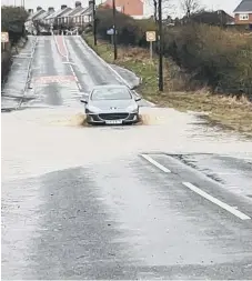  ??  ?? A car going through the flooding on Murton Lane.