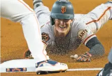  ?? David J. Phillip / Associated Press ?? The Giants’ Mike Yastrzemsk­i dives for third base to gain a first inning triple in a loss to the Astros.