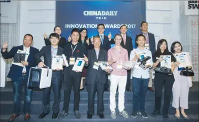  ?? ROY LIU / CHINA DAILY ?? Winners of China Daily Innovation Award 2017 display their award-wining inventions and trophies with presenters at the Global Sources Electronic­s show in Hong Kong’s AsiaWorld-Expo exhibition center on Wednesday.