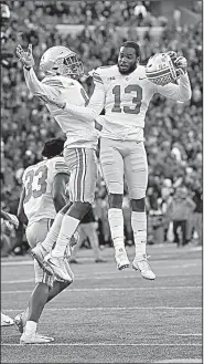  ?? AP/NICK WASS ?? Ohio State cornerback­s Tyreke Johnson (13) and Kendall Sheffield (left center) celebrate after the Buckeyes defeated Maryland 5251 in overtime.