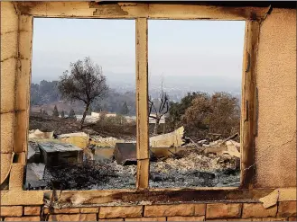  ?? Associated Press photo ?? An exterior window frames a home destroyed by fires in Santa Rosa, Calif., Thursday. Gusting winds and dry air forecast for Thursday could drive the next wave of devastatin­g wildfires that are already well on their way to becoming the deadliest and...