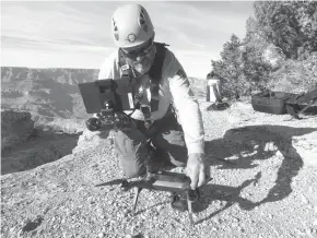  ?? Grand Canyon National Park via AP ?? A Grand Canyon National Park employee operates a drone in 2016 at the park. The Grand Canyon is the only national park with its own fleet of unmanned aircraft for reaching people who have gotten lost, stranded, injured or killed. Under a program that...