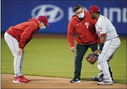  ?? FRANK FRANKLIN II - THE ASSOCIATED PRESS ?? Phillies manager Joe Girardi, left, watches as a trainer checks on shortstop Jean Segura, right, during the sixth inning.