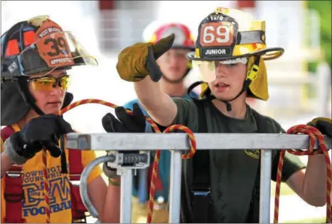  ?? PHOTOS BY PETE BANNAN — DIGITAL FIRST MEDIA ?? Lucas Richardson of Twin Valley Fire Company,right, helps Sam Curdo of West Bradford Fire Company as they tie the clove hitch knot Chester County Department of Emergency Services’ Junior Public Safety Camp Olympics Thursday at the Chester County Public...