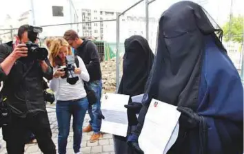  ?? AP ?? Two sisters who were fined each €50 after they were caught wearing the full veil in public show their citations to media in Brussels, in 2011.