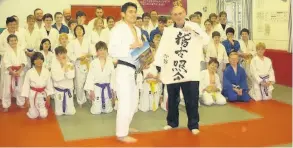  ??  ?? Masaki Nigishi presents Peter Thatcher a Japanese scrool to commemorat­e his 50-year involvemen­t with Bath Judo Club
