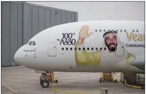  ?? Bloomberg/JASPER JUINEN ?? A portrait of Sheikh Ahmed bin Saeed Al Maktoum, chief executive officer of Emirates Airlines, adorns an Airbus SE A380 aircraft as Emirates take delivery of their 100th A380 passenger jet in Hamburg, Germany, in early November.