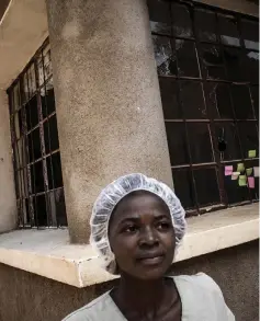  ??  ?? A health worker stands in front of a window riddled with bullet holes in an Ebola treatment centre, which was attacked in the early hours of the morning in Butembo and (right) Health workers are seen inside the ‘red zone’ of an Ebola treatment centre.