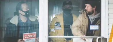  ?? CARLOS OSORIO / REUTERS; CARLOS OSORIO / REUTERS; PETER J THOMPSON / NATIONAL POST ?? Adam Skelly, owner of Adamson Barbecue, was forced to place a closed sign at his Etobicoke, Ont., location Tuesday
afternoon, hours after defiantly opening to indoor diners despite COVID-19 restrictio­ns.