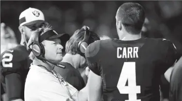  ?? JANE TYSKA/TRIBUNE NEWS SERVICE ?? Oakland Raiders head coach Jon Gruden talks with quarterbac­k Derek Carr (4) after Carr gave up an intercepti­on in Oakland on Sept. 10.