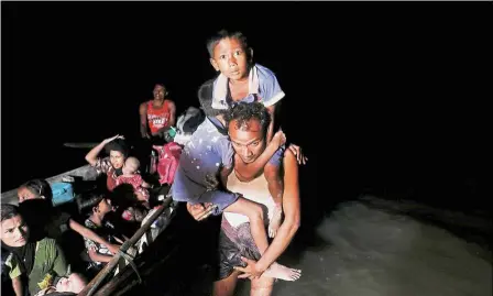  ??  ?? Refugees making their way to the shore of Shah Porir Dwip in Teknaf after arriving under cover of darkness by a wooden boat from Myanmar. — Reuters Fleeing to stay alive: