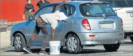  ?? Picture: MICHAEL PINYANA ?? NOT A DESIGNATED SPOT: Car washers on the East London Esplanade say metro law enforcers take away their soap and buckets