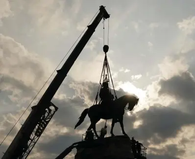  ?? Ap FILe ?? CHANGES: Crews work to remove one of the country’s largest remaining monuments to the Confederac­y, a towering statue of Confederat­e Gen. Robert E. Lee on Monument Avenue in Richmond, Va., on Wednesday.