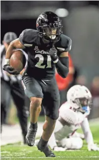  ?? ‘KATIE STRATMAN/USA TODAY SPORTS ?? Cincinnati wide receiver Tyler Scott (21) runs for a touchdown against Temple on Friday night.