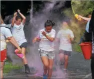  ?? MARIAN DENNIS – DIGITAL FIRST MEDIA ?? Pink and yellow powder flew through the air Saturday as runners celebrated their approach to the finish line at the Race Against Racism in Riverfront Park.