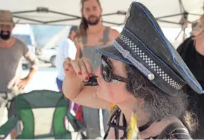  ?? TREVOR HUGHES/USA TODAY NETWORK ?? A Burning Man participan­t who would give her name only as Too Cute, 42, eats a piece of sushi made for her by a stranger. “Gifting,” the giving of food and other items without expectatio­n of repayment, is a major tenet of Burning Man.