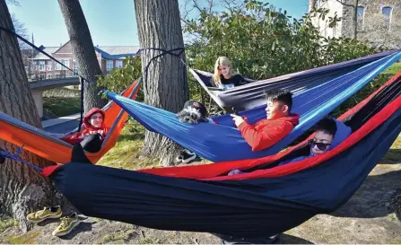  ?? ?? HANGING OUT: WPI students Emre Sabat, Sol Giesso, Dang Nguyen with Duchess and Rayuth San hook up their hammocks off campus on Sunday.