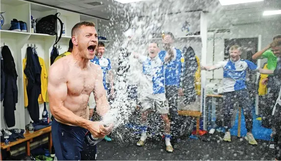  ?? Picture: Harry Trump/Getty ?? Paul Coutts cracks open a bottle of champagne following Bristol Rovers’ promotion