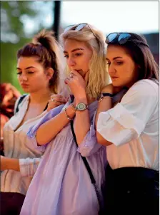  ?? AFP ?? People pause during floral tributes to the victims of the manchester terror attack in New england. —
