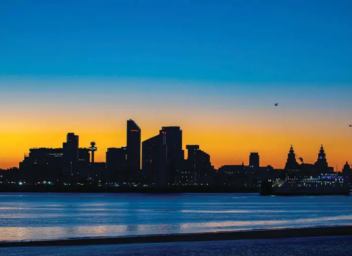  ??  ?? The sun rises behind the Liverpool waterfront, north west England, yesterday. Photo: AP