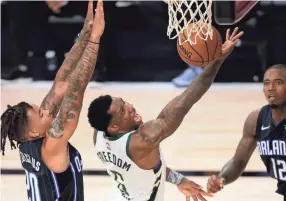  ?? MIKE EHRMANN/POOL PHOTO VIA USA TODAY SPORTS ?? The Bucks’ Eric Bledsoe (6) goes up for a shot against the Magic’s Markelle Fultz in Game 3 on Saturday.