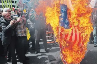  ?? VAHID SALEMI
THE ASSOCIATED PRESS ?? Iranian protesters burn a representa­tion of a U.S. flag during a gathering after Friday prayers in Tehran . Thousands of Iranians took to the streets to protest Donald Trump’s decision to pull out of the nuclear deal.