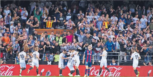  ??  ?? Los aficionado­s del Valencia celebran un gol de su equipo ante el Barcelona en un partido disputado antes de la pandemia en el estadio de Mestalla.