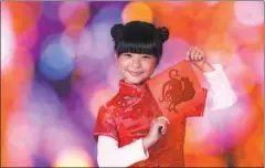  ?? PHOTOS PROVIDED TO CHINA DAILY ?? From left: A girl presents a rooster-shaped Chinese paper-cut; a rooster-themed lantern fair at Yuyuan Garden in Shanghai.