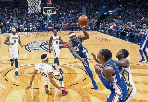  ??  ?? Out of my way: Philadelph­ia 76ers forward Trevor Booker (third from right) going for the basket as New Orleans Pelicans forward Anthony Davis (second from left) tries to defend in the NBA game on Sunday. Bottom: Dallas Mavericks guard J. J. Barea falls...