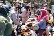  ?? AZAMI RAMADAN/JAWA POS ?? DIRAZIA: Aparat gabungan TNI, Polri, dan Satpol PP Kota Surabaya mencegat warga yang tidak memakai masker saat melintas di depan Puskesmas Sidotopo kemarin.