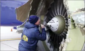  ?? NTSB VIA AP ?? In this Tuesday photo, a National Transporta­tion Safety Board investigat­or examines damage to the engine of the Southwest Airlines plane that made an emergency landing at Philadelph­ia Internatio­nal Airport in Philadelph­ia.