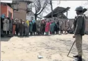  ?? HT FILE ?? A security personnel stands guard as people line up to vote during the last panchayat polls held in Jammu and Kashmir in 2011.