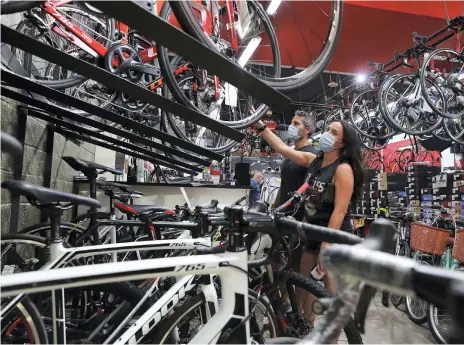  ?? Photos Pawan Singh / The National ?? Stephen Finnegan and Tara Powderly from Ireland shop at Revolution Cycles store in Motor City