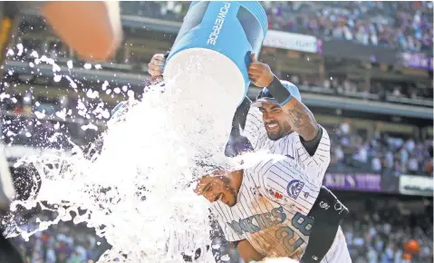  ?? CHRIS HUMPHREYS, USA TODAY SPORTS ?? Nolan Arenado is doused after hitting a walk- off home run to give the first- place Rockies a victory against the Giants on Sunday.