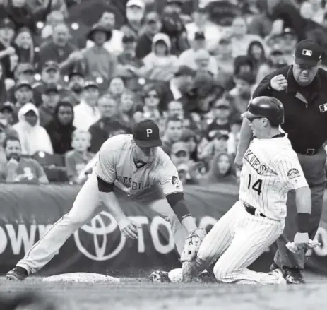  ?? John Leyba, The Denver Post ?? Rockies catcher Tony Wolters is tagged out by Pirates third baseman David Freese. Freese drove in a pair of runs during Friday night’s offensive battle at Coors Field. The game was the first of a three-game set between the Pirates and Rockies.