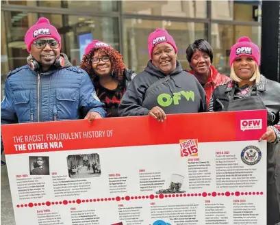  ?? COURTESY OF NATAKI RHODES/WBEZ ?? One Fair Wage members hold a poster outside of the National Restaurant Associatio­n’s office in the Loop during a February rally.