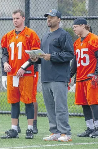  ?? RIC ERNST/ PNG ?? Quarterbac­k Rudy Carpenter, left, quarterbac­ks coach Jarious Jackson and running back Stuart Foord watch an offensive drill during the B. C. Lions’ three- day mini- camp that opened Tuesday.